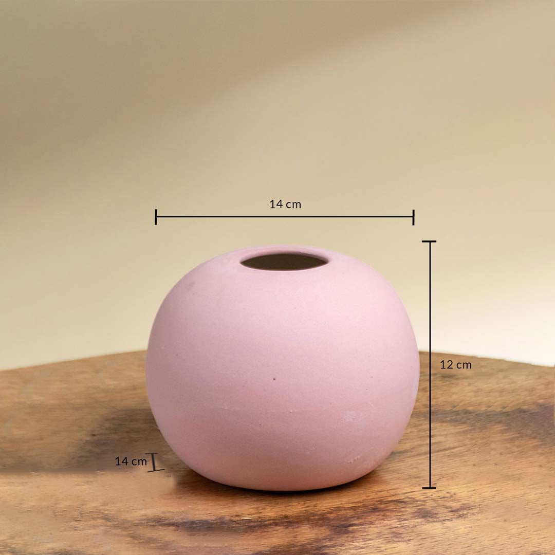 Pink ceramic round vase shown with 14 cm width 12 cm height and 14 cm depth on a wooden surface for accurate product sizing.