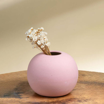 Pink ceramic round vase displayed with flowers on a cozy side table enhancing living room decor with a soft warm aesthetic for elegant interior styling.