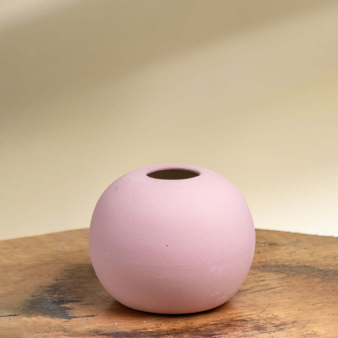 Minimal pink ceramic sphere vase with smooth matte texture shown on a white background perfect for tabletop and shelf decor.