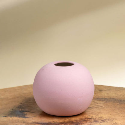 Minimal pink ceramic sphere vase with smooth matte texture shown on a white background perfect for tabletop and shelf decor.