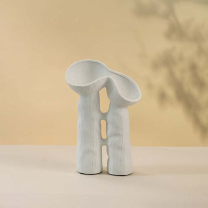 Modern minimalist white ceramic vase featuring creative sculptural curves and twin openings in matte finish against white background.