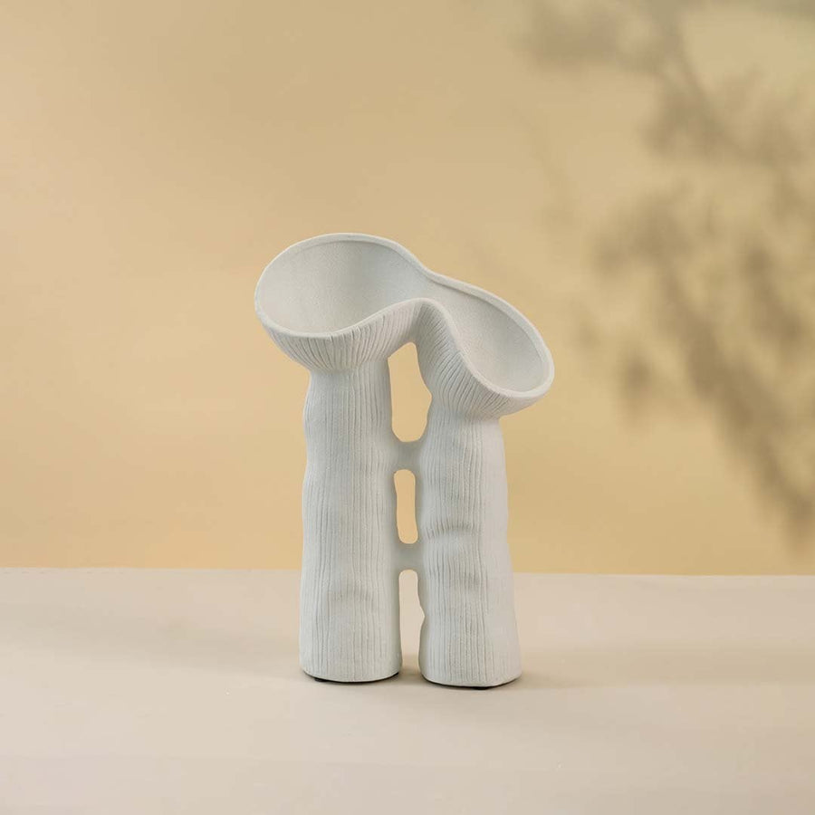Modern minimalist white ceramic vase featuring creative sculptural curves and twin openings in matte finish against white background.