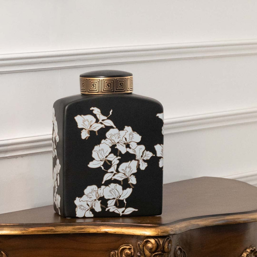 Black ceramic jar decorated with white cherry blossom artwork designed for oriental décor adding artistic contrast handcrafted beauty and elegant detailing to sophisticated interior spaces.