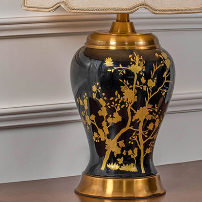 Closeup of black and gold ceramic table lamp showing detailed floral patterns gold accents and fabric shade emphasizing luxury handcrafted design.