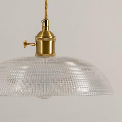 Detailed view of clear textured glass pendant light with polished gold fittings and timeless appeal.