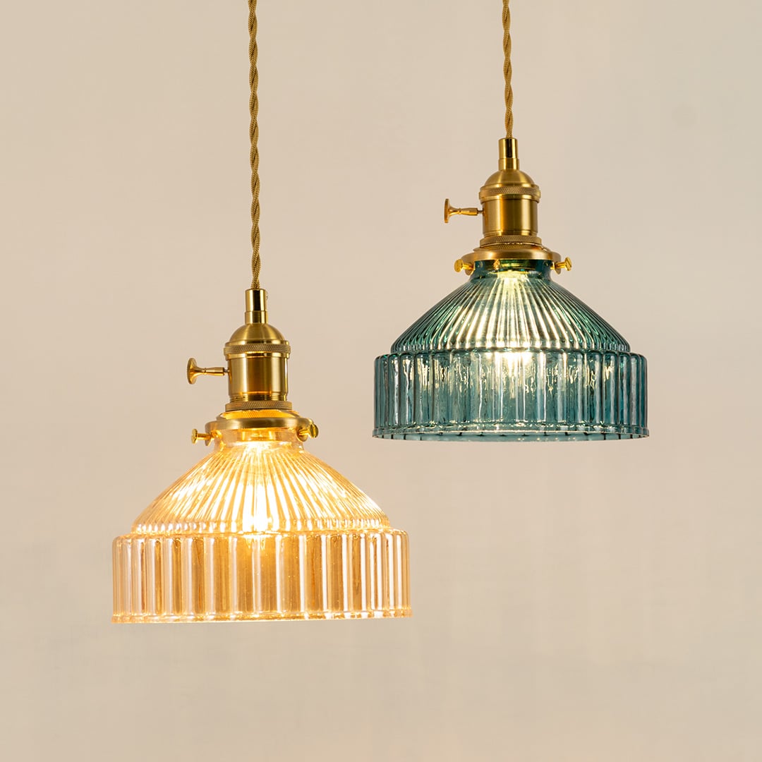 Gold metal pendant lights with blue and amber ribbed glass shades illuminated to highlight premium craftsmanship.
