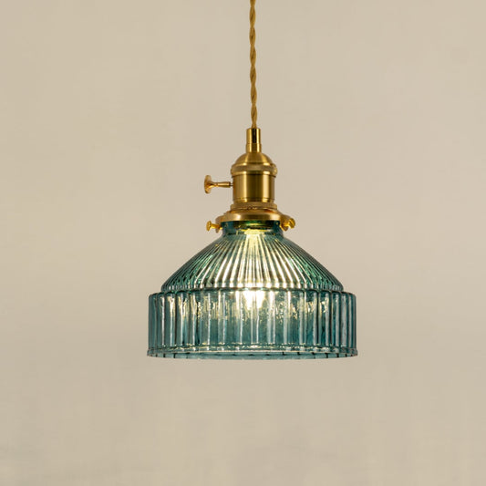 Gold metal pendant light with blue ribbed glass shade illuminated to highlight elegant decorative ceiling lighting.