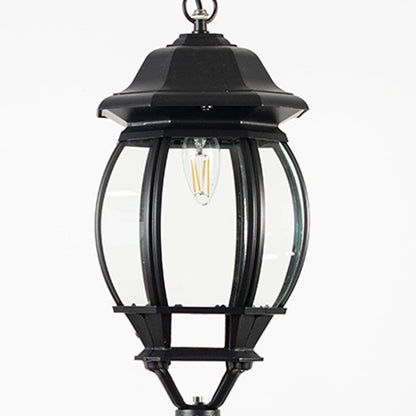 Closeup of outdoor hanging lantern light showing bulb reflection and detailed glass pattern.