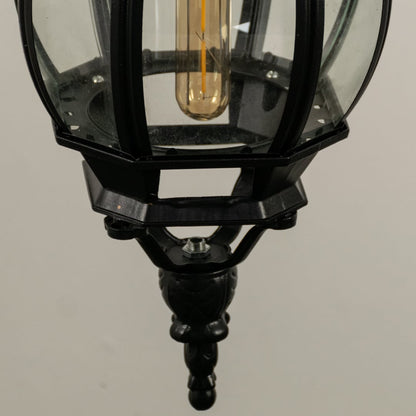 Detailed closeup of hanging lantern light focusing on curved glass and metallic black design.