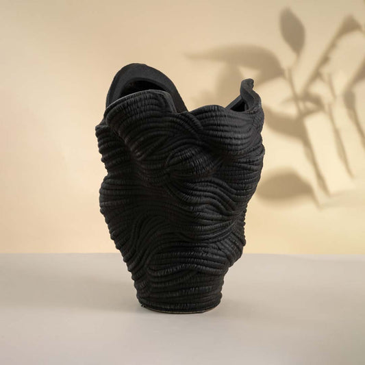 Black ceramic decorative sculpture with organic textured form for contemporary shelf styling and modern home decor.