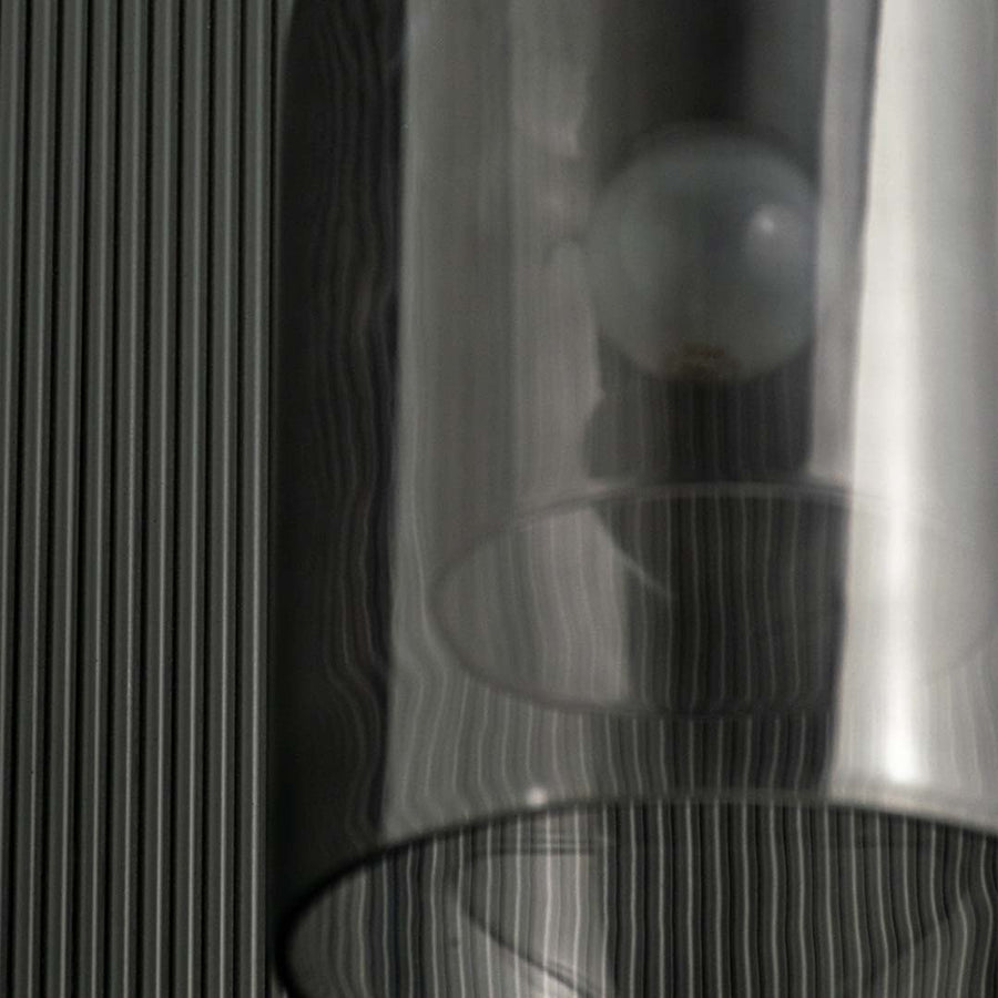 A closeup of the smoked glass dome pendant light highlighting its glowing filament bulb and smooth curved glass design for elegant interior lighting.