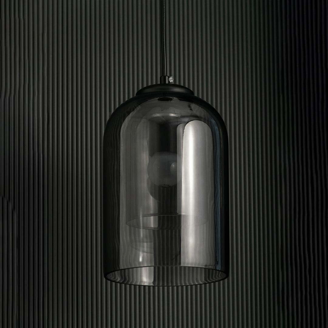 A smoked glass dome pendant light shown with lights off against a dark background emphasizing its glossy curved silhouette and modern aesthetic.