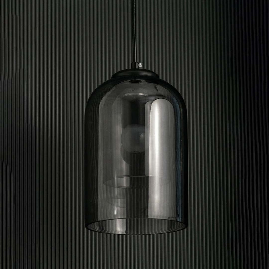 A smoked glass dome pendant light shown with lights off against a dark background emphasizing its glossy curved silhouette and modern aesthetic.
