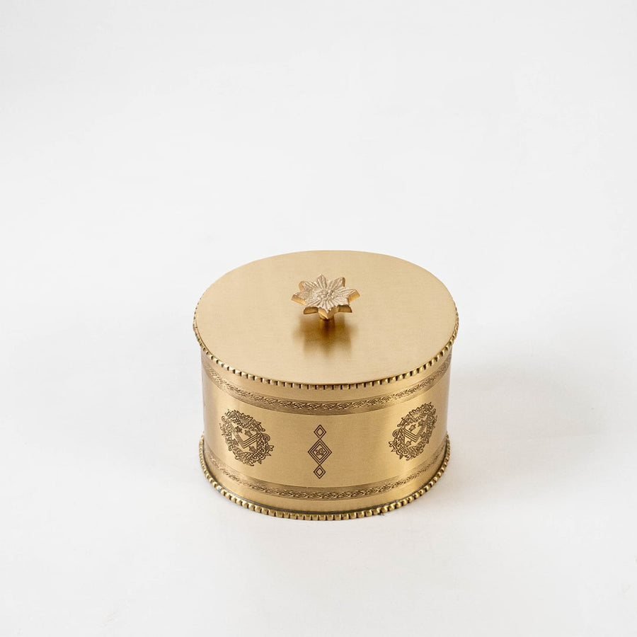 Gold metal round storage jar with engraved details shown on white background with measurements 13 cm by 11.5 cm.