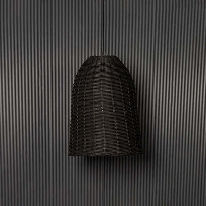 Black rattan pendant light on black background highlighting its artisanal weave and natural contours.
