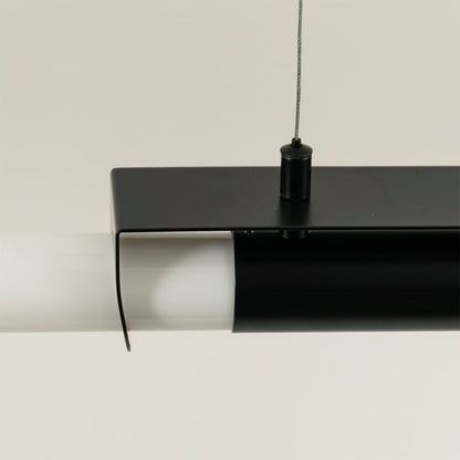 Closeup of black metal pendant light showing sleek frame and white acrylic tube for modern ceiling decor focus.