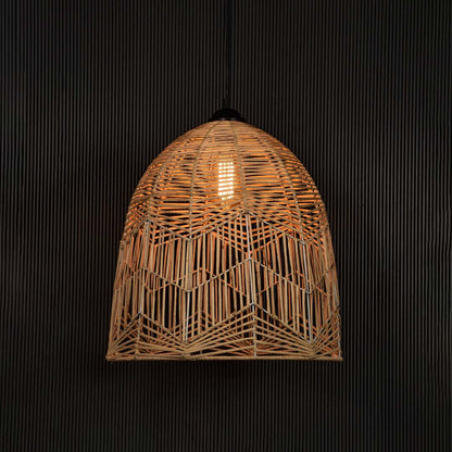 Woven bamboo pendant light glowing on dark background creating a cozy ambience with warm soft illumination.