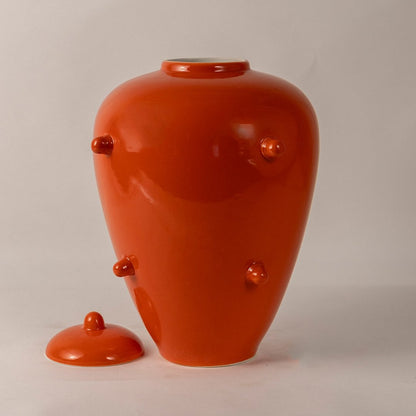 Bright orange ceramic ginger jar with lid and decorative knobs perfect for bold home decor and modern interiors.
