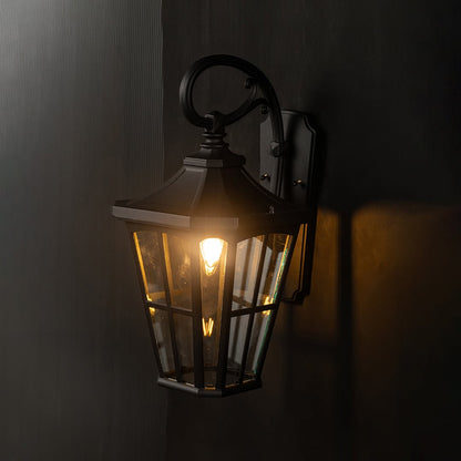 Decorative lantern gate light glowing against a black background for dramatic effect.