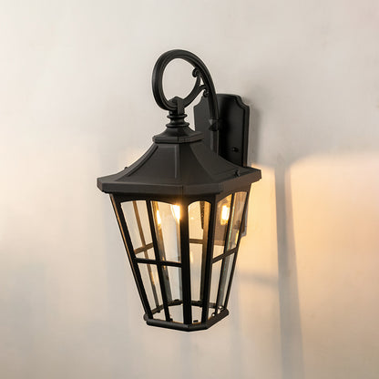 Black metal outdoor wall light on white background with tapered paneled clear glass shade for patio decor.