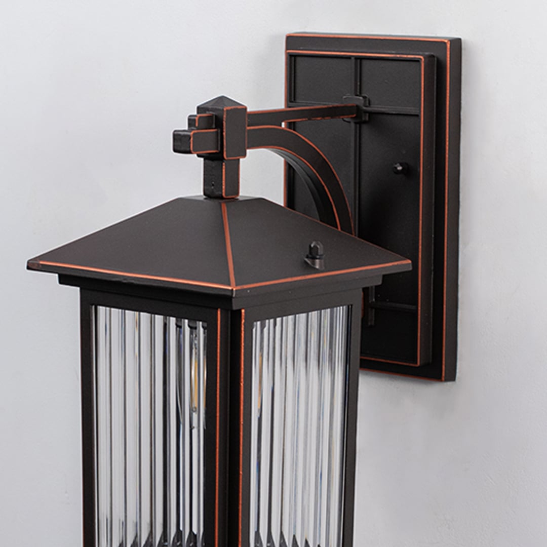 Bronze metal outdoor wall light closeup image with textured fluted glass shade and elegant copper trim accents for decor.