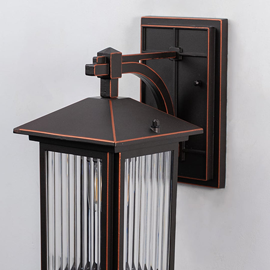 Bronze metal outdoor wall light closeup image with textured fluted glass shade and elegant copper trim accents for decor.