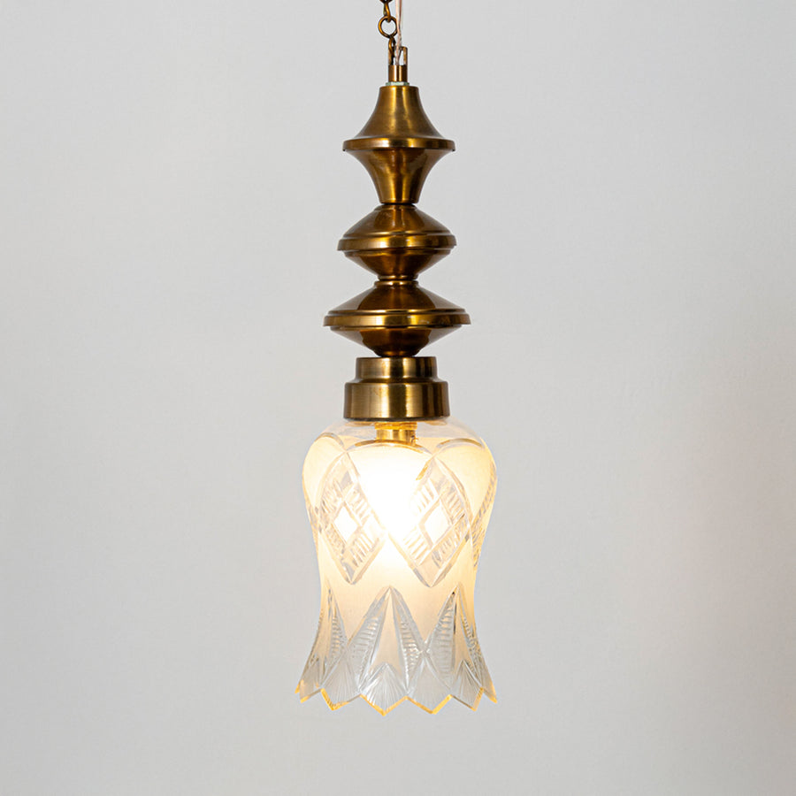 Decorative pendant light in gold metal finish with glass shade for dining room or living decor lighting white background.