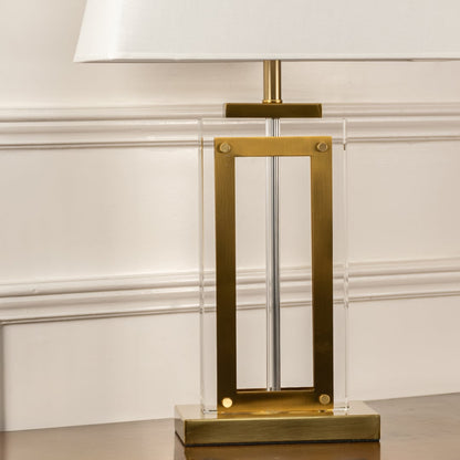 Detailed view of gold table lamp showing the metallic finish  sharp rectangular structure  and textured linen shade.