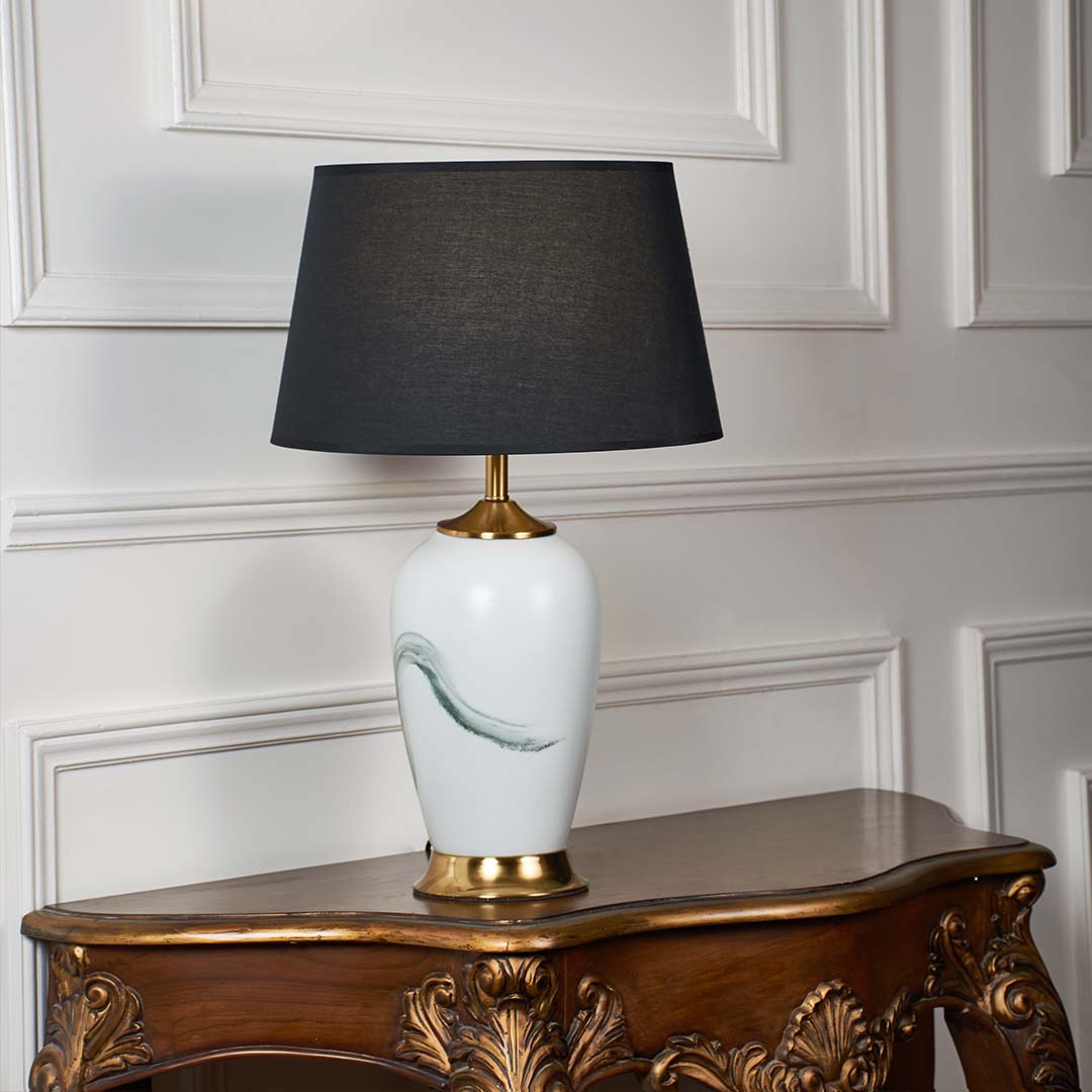 White ceramic table lamp with grey fabric shade and gold accents offering contemporary style and ambient table lighting.