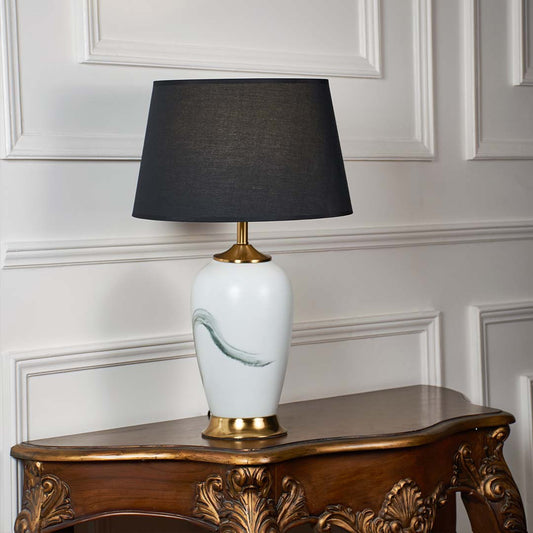 White ceramic table lamp with grey fabric shade and gold accents offering contemporary style and ambient table lighting.