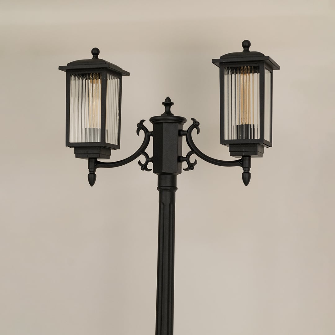 Closeup of black metal outdoor lantern showing ribbed glass and elegant frame details perfect for enhancing driveway garden and entryway Decor.