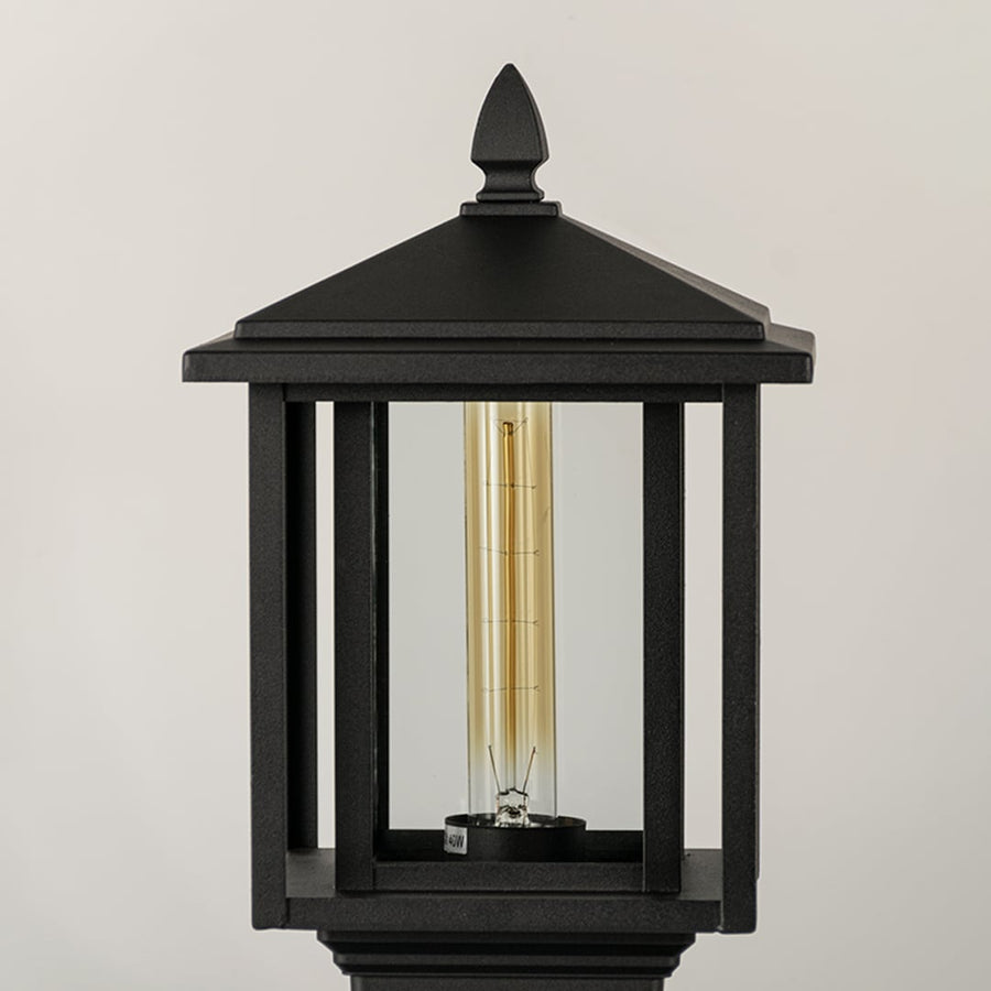 Black outdoor lantern Closeup Light On showing warm glow and decorative pebbled glass panels for exterior lighting.