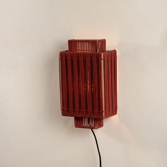 Red textured wall light with rectangular design and warm glow perfect for modern bedroom or hallway wall decor placement.