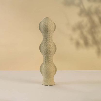 Contemporary beige ceramic vase with curved silhouette and textured surface against white background perfect for adding sophistication to modern home interiors.