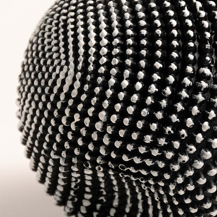 Closeup of black and white textured sphere sculpture showing intricate pattern and fine details.