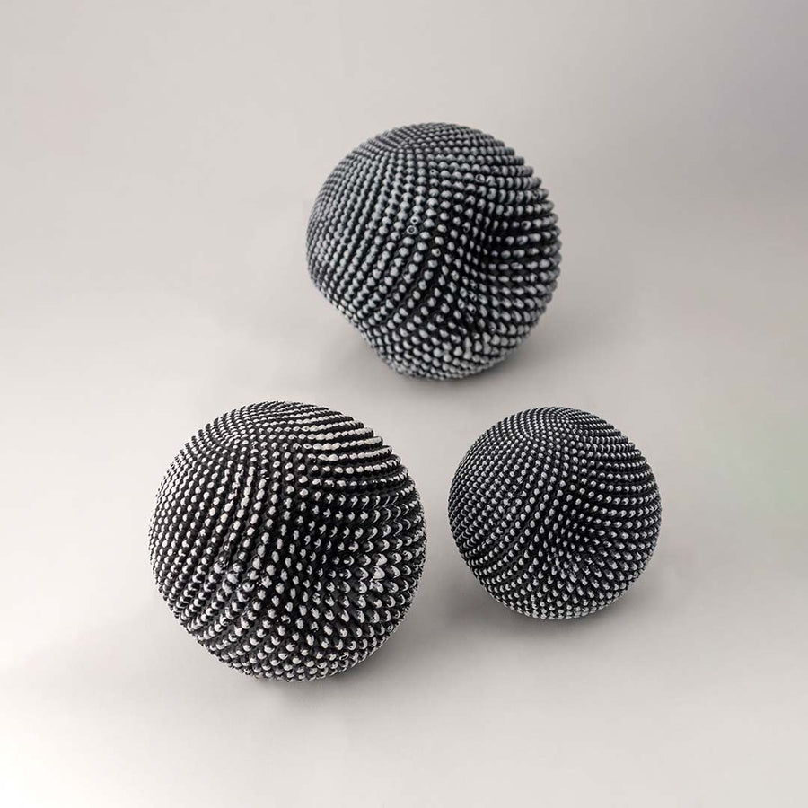 Set of black textured decorative spheres for elegant shelf styling and contemporary tabletop home decor displays.