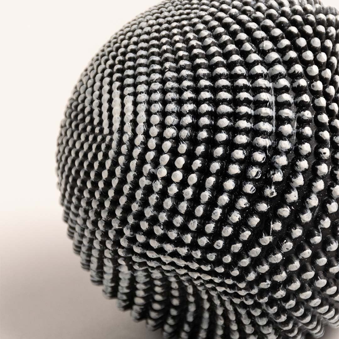 Closeup of black and white textured ball sculpture showcasing intricate pattern and unique design details.