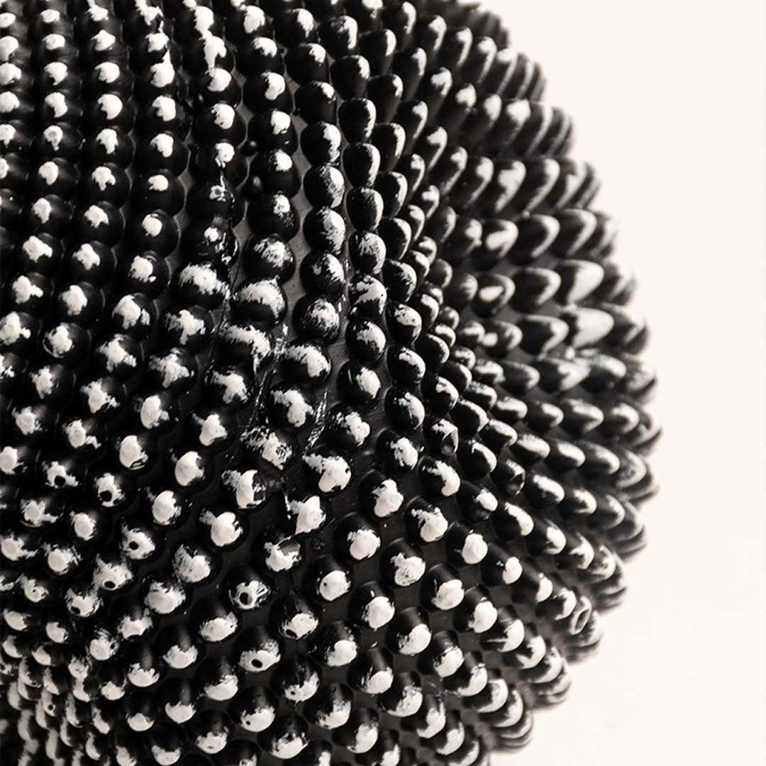 Closeup of black and white textured sphere sculpture showing intricate pattern and fine details.