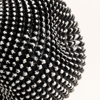 Closeup of black and white textured sphere sculpture showing intricate pattern and fine details.