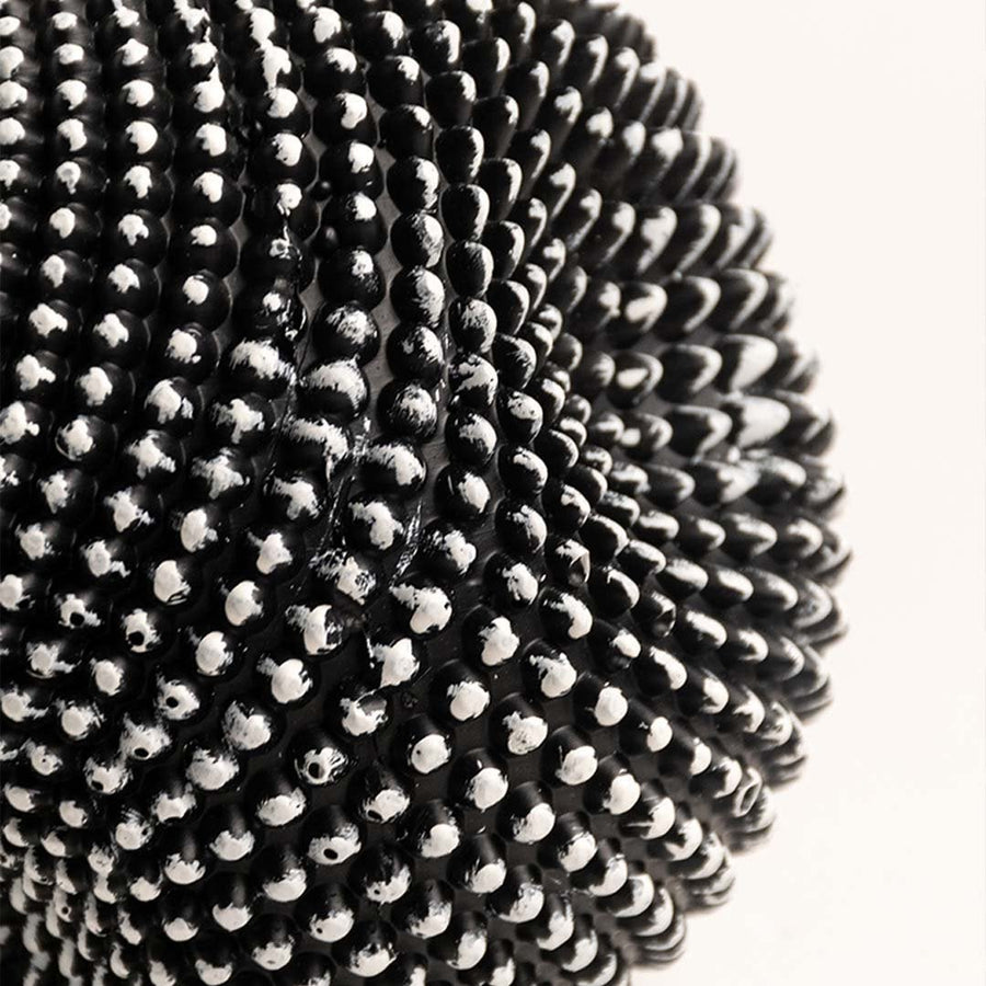 Closeup of black and white textured sphere sculpture showing intricate pattern and fine details.