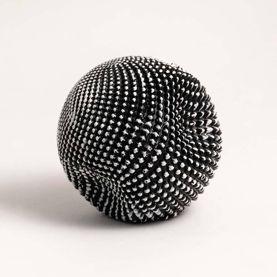 Stylish black and white textured sphere sculpture displayed against plain white background to emphasize design.