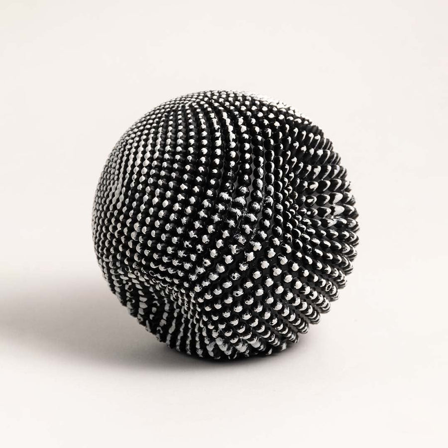 Stylish black and white textured sphere sculpture displayed against plain white background to emphasize design.