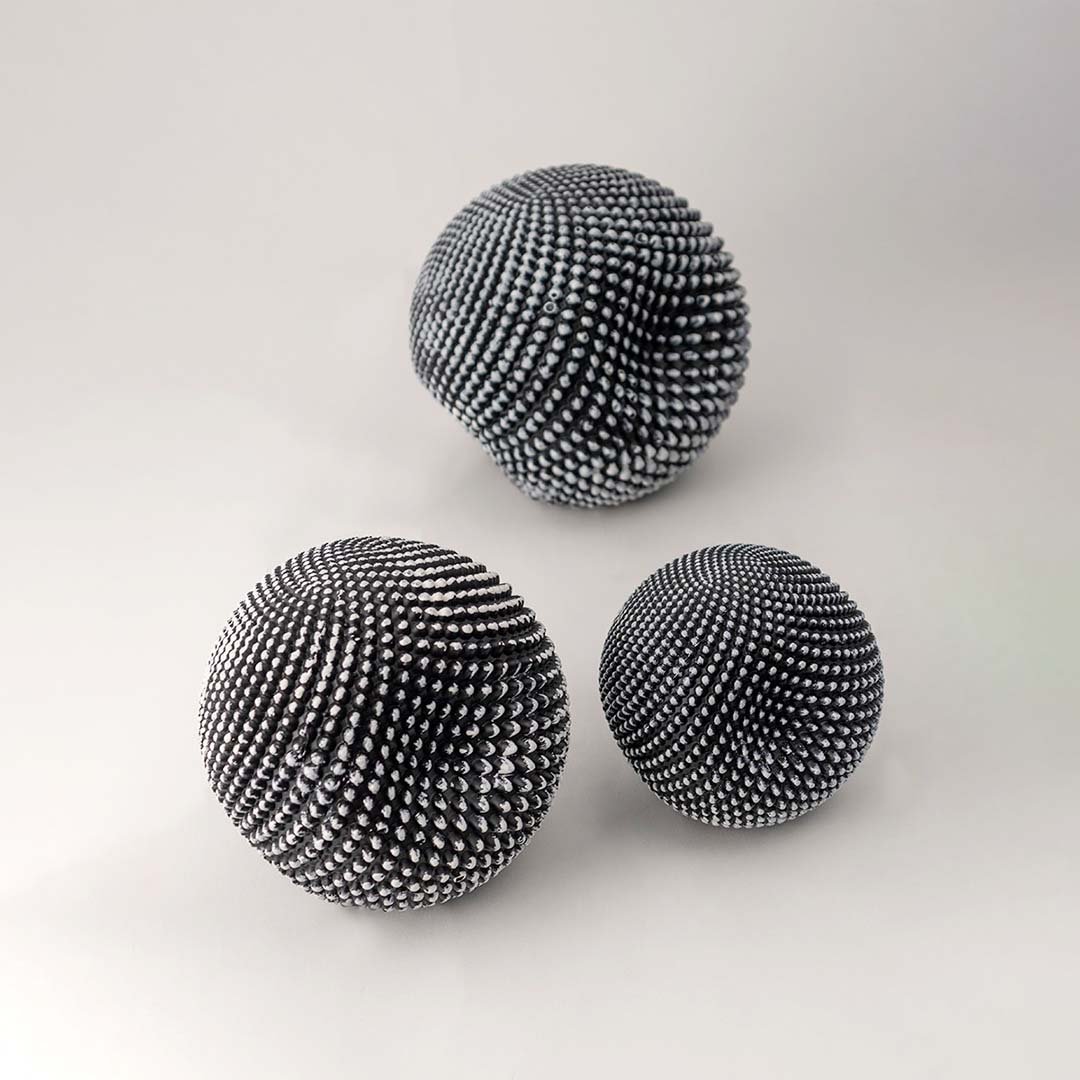 Black decorative sphere set with textured finish for artistic shelf styling and contemporary home decor displays.