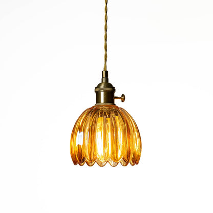 Amber ribbed glass pendant light with antique brass accents creating cozy illumination indoors.