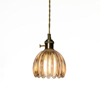 Illuminated amber ribbed glass pendant light casting warm ambient lighting for stylish living spaces.