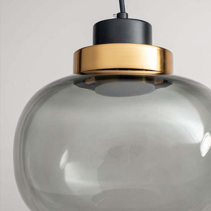Closeup of smoked glass pendant light with golden detailing and black cord stylish modern ceiling lamp for home decor lighting.