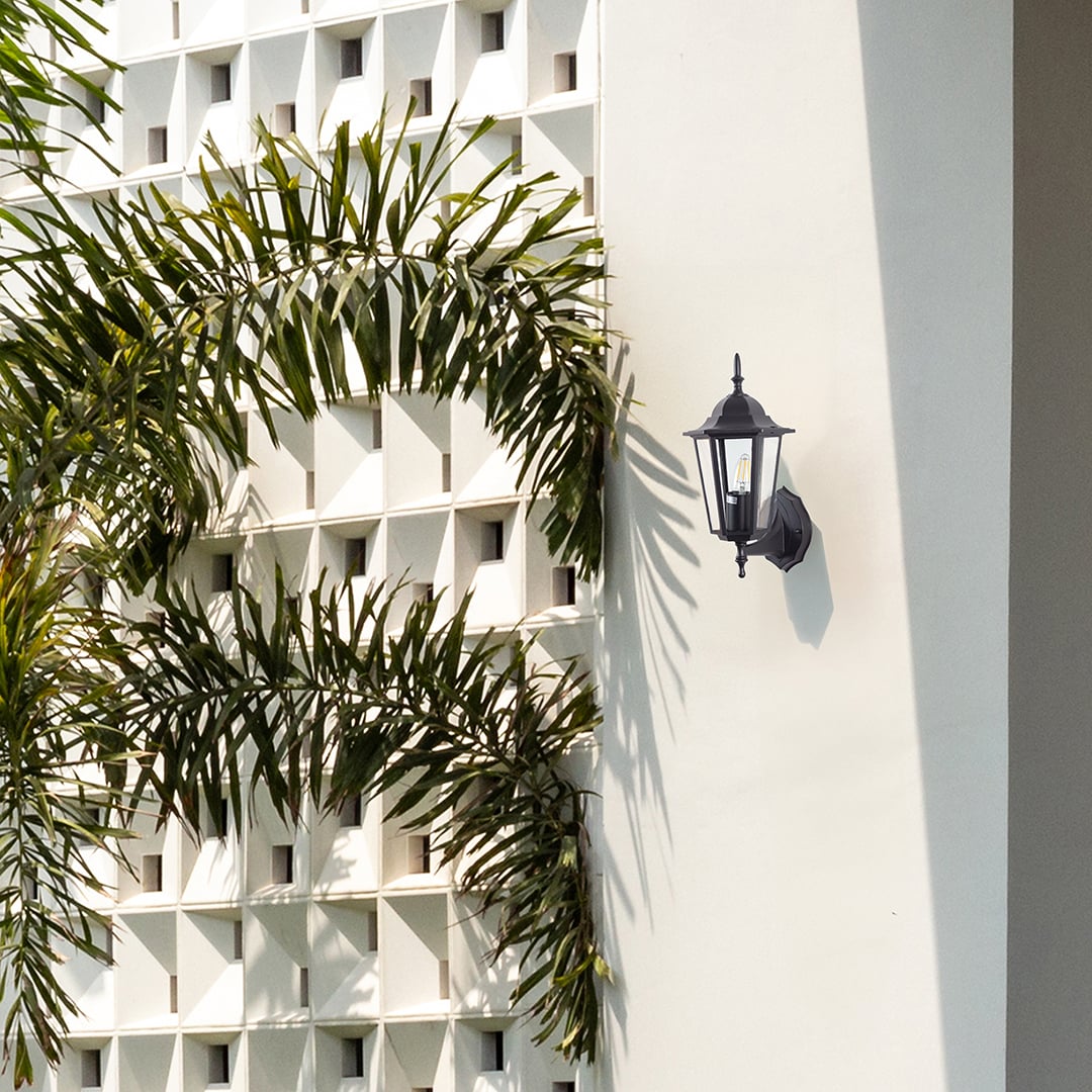 Black metal outdoor wall light lifestyle image on modern exterior wall for stylish patio lighting decor.