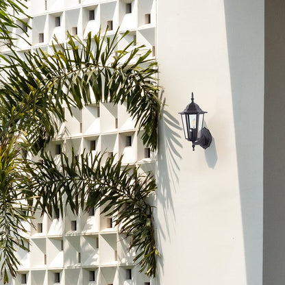 Black metal outdoor wall light lifestyle image on modern exterior wall for stylish patio lighting decor.