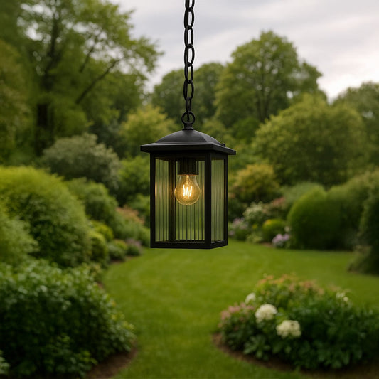 Outdoor black metal hanging lantern with ribbed glass panels styled for porch and patio lighting in a warm inviting setting.