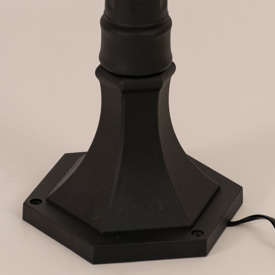 Detailed closeup of black outdoor post lamp showing textured metal body and ribbed glass for refined outdoor decor.